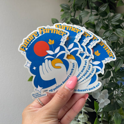 Hand holding a stack of gloss die cut stickers with the text 'Future Farmer' and an illustration of a hand holding a plant with a sun and stars in the background, and additional text 'if politics doesn't work out'.