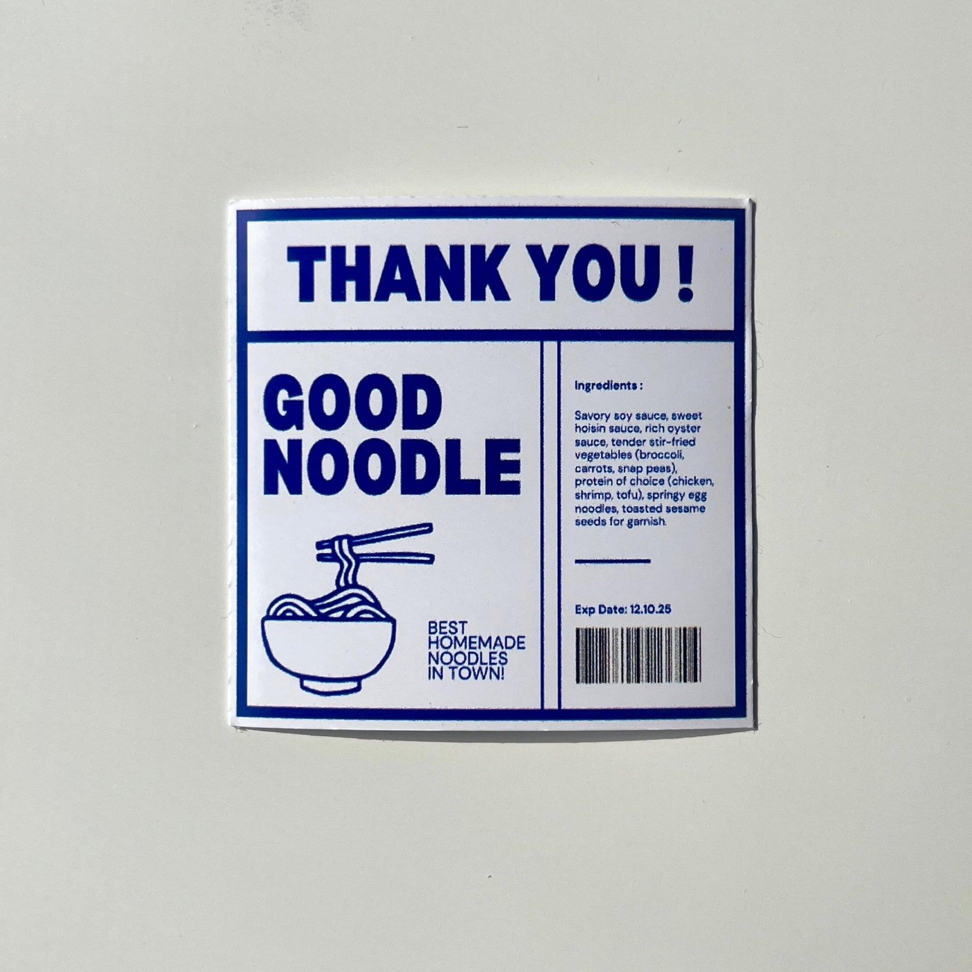 A square sticker with a white background featuring the text "THANK YOU!" in large blue letters at the top. Below it, the text reads "GOOD NOODLE" next to an illustration of a bowl with chopsticks. The right side includes a list of ingredients, a barcode, and the expiration date.